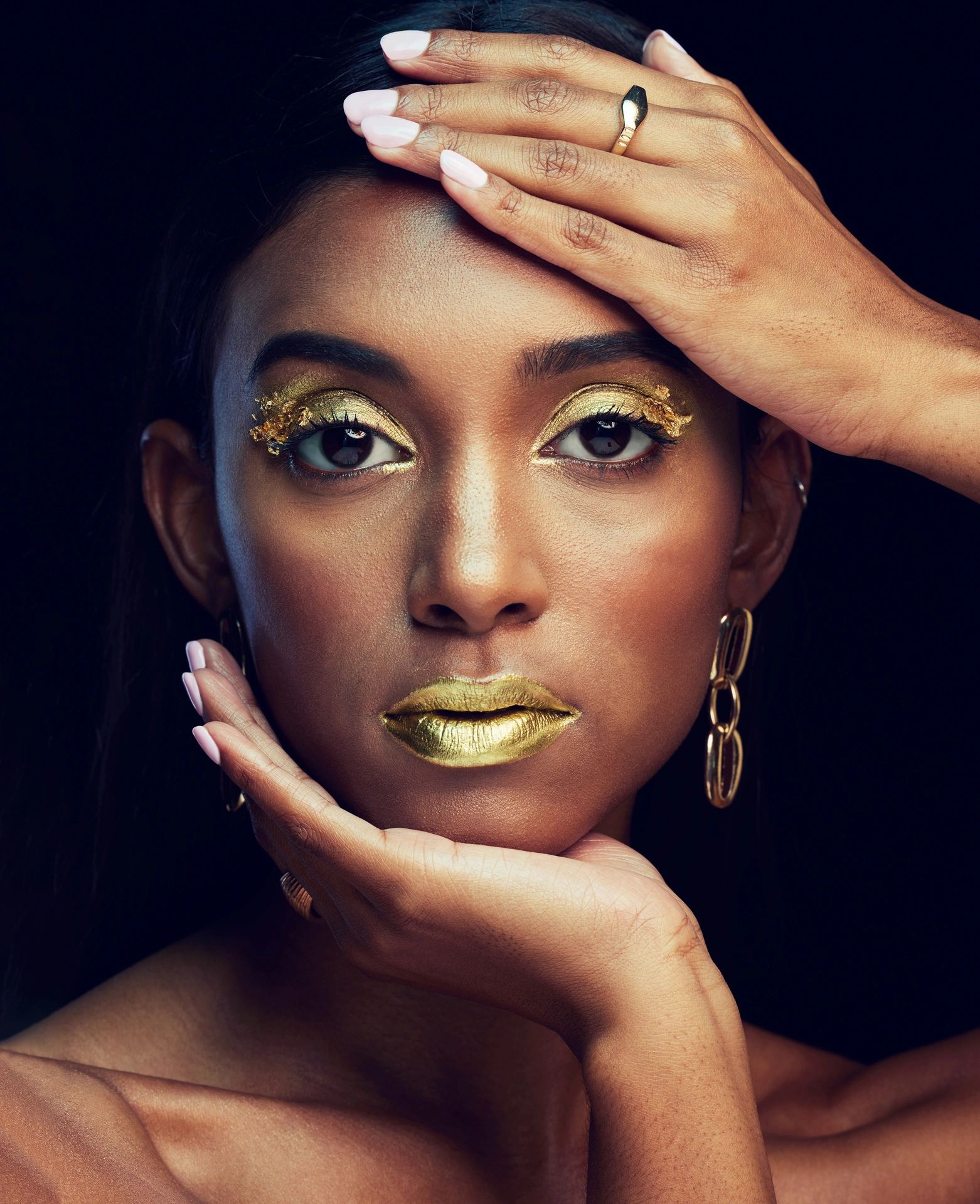 Indian woman, art makeup and studio portrait for beauty, wellness or celebration by black background. Model face, asian girl and dark aesthetic with gold lipstick, jewellery or cosmetic for a queen