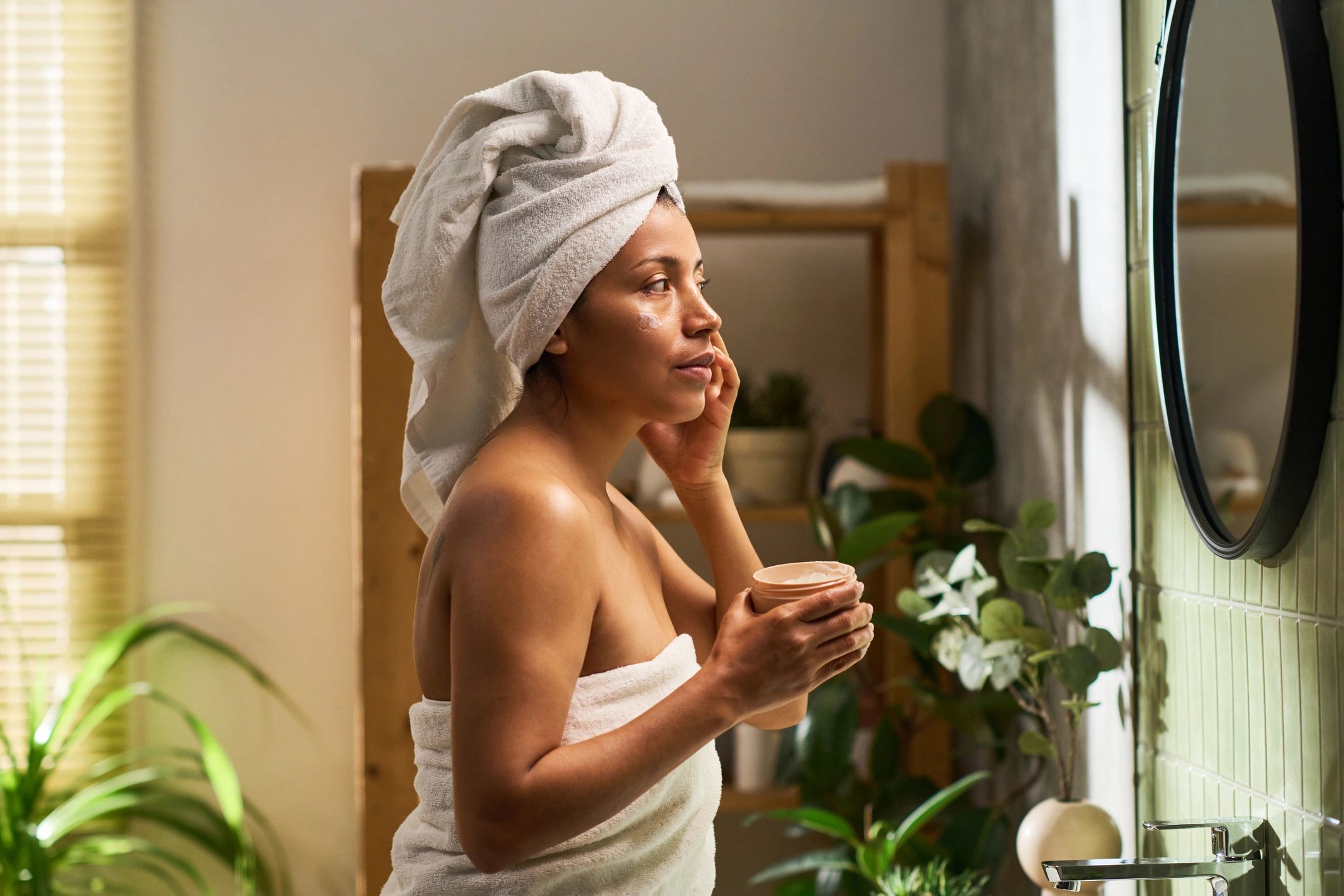 Woman applying face cream during skincare routine